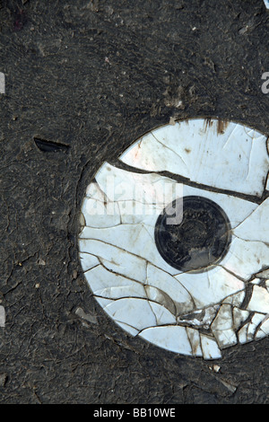eine alte beschädigte cd Compcat Disk auf Fahrbahn Stockfoto