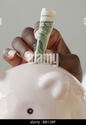 Afrikanerin, Geld im Sparschwein Stockfoto