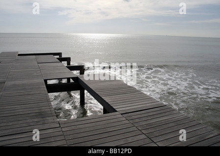 Loch in eine hölzerne Pier Anlegestelle auf dem Seeweg Stockfoto