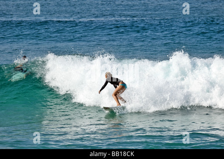 Surfer fängt eine Welle für eine Fahrt ins Ufer am späten Nachmittag