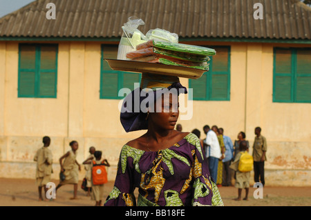 Benin Porto Novo Frau, die eine Paket auf dem Kopf trägt gekleidet in traditioneller afrikanischer Kleidung Stockfoto