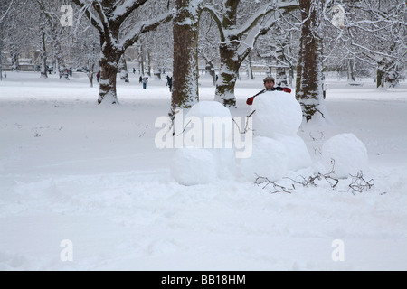 Mann macht einen Schneemann Stockfoto
