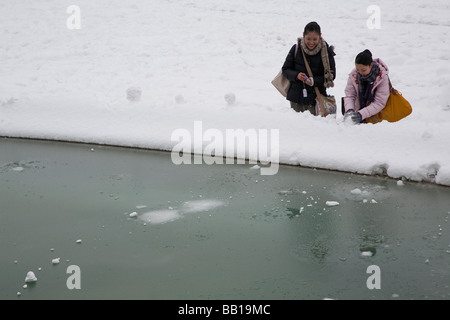 Zwei junge Frau die Schneebälle in Brunnen werfen Stockfoto