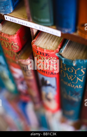 Alten Jungen eigene Bücher auf einem Regal in einem antiken Buchhandlung Stockfoto