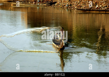 MALI, Djenné. Fischer in seinem Einbaum stehen, wirft ein Netz im Fluss Niger (RF) Stockfoto