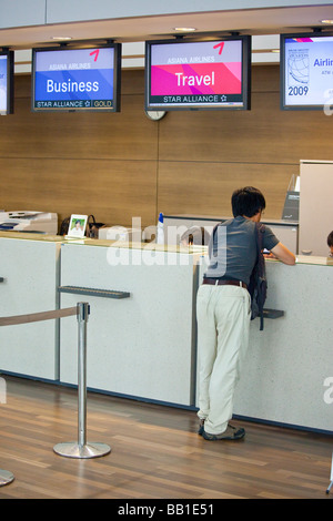 Koreanische Jüngling bei Asiana Airlines Zähler in ICN Seoul Incheon Flughafen Stockfoto