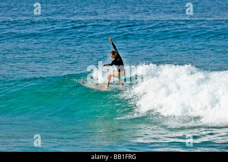 Surfer fängt eine Welle für eine Fahrt ins Ufer am späten Nachmittag