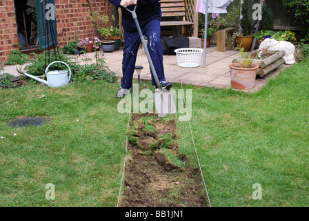 Mann Rasen für neuen Gartenweg in modernen britischen Haus ausgraben Stockfoto