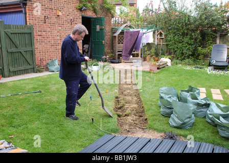 Mann Rasen für neuen Gartenweg in modernen britischen Haus ausgraben Stockfoto