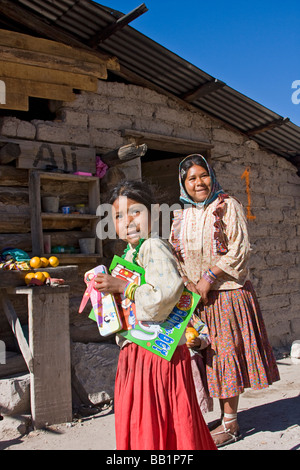 Junge Mutter mit ihren Töchtern stehen durch ihre Adobe und Blockhaus in der Tarahumara Dorf von San Alonso in Copper Canyon Stockfoto