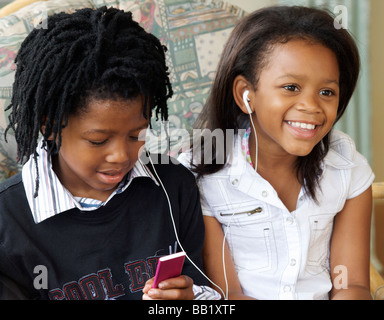 Jungen und Mädchen hören nach den gleichen mp3 Spieler, Pietermaritzburg, Provinz KwaZulu-Natal, Südafrika Stockfoto