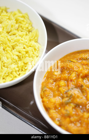 Indische oder asiatische Stil Masala Dal mit gelber Reis Pilaw diente In weißen Schüsseln mit Keine Personen Stockfoto