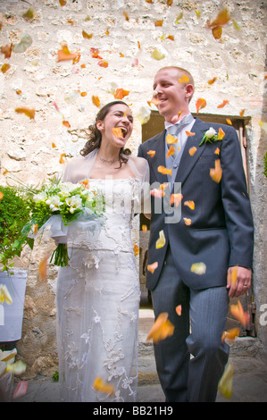 Brautpaar mit geworfenen Blütenblättern Kundendienst Stockfoto