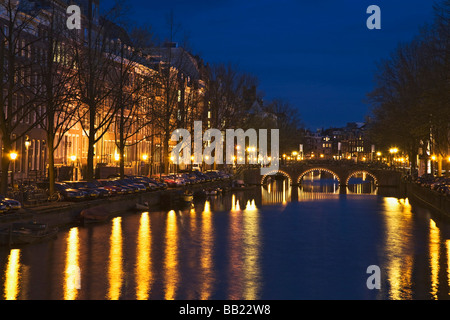 Europa, Niederlande, Amsterdam. Brücke und Licht reflektieren über steile Kanal in der Nacht. Stockfoto