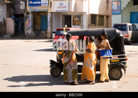 Drei Frauen zahlen einen Rikscha-Fahrer in der ehemaligen portugiesischen Kolonie von Diu, Indien. Stockfoto