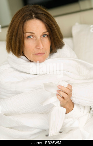 Porträt einer Frau, eingewickelt in eine Decke und Holding-Tissue-Papier Stockfoto