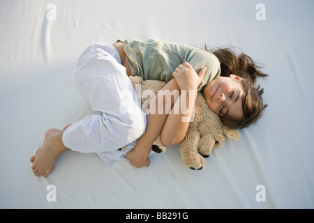 Erhöhte Ansicht eines Mädchens mit einem Teddy Bären schlafen Stockfoto