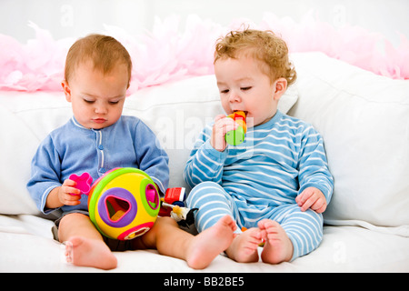 Zwei Babys spielen mit Spielzeug Stockfoto