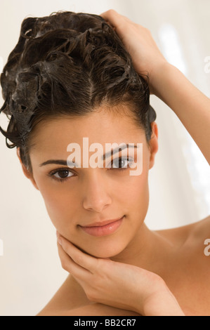 Porträt einer Frau, ihr Haar Shampoonieren Stockfoto