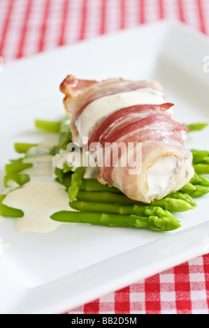 leckere Seeteufel eingewickelt in Speck mit frischem Spargel Stockfoto