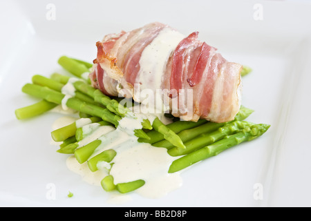 Frischer Seeteufel eingewickelt in Speck mit Zitrone Mayonaise und Spargel Stockfoto