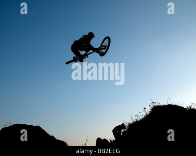 Junge mit dem Fahrrad und macht einen großen Sprung Stockfoto