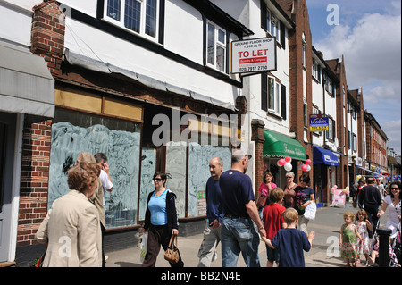 Eine geschlossen nach unten Shop mit Menschen zu Fuß vorbei an der Ladenfront im Banstead High Street Surrey UK Stockfoto