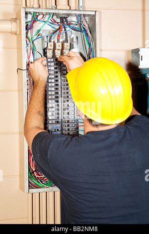 Elektriker ersetzen einen schlechten Leistungsschalter in einem großen industriellen Bereich Stockfoto