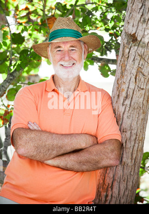 Hübscher senior Mann trägt einen Panama-Hut und stehen im Schatten Stockfoto