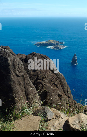 Petroglyphen auf Felsen mit Blick auf die kleine Insel an der zeremoniellen Dorf Orongo, Osterinsel, Chile. Stockfoto