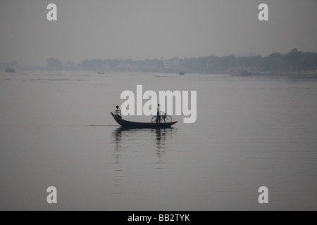 Alltag in Bangladesch;  Ein Wassertaxi Zeilen ein Mann und sein Fahrrad über den Fluss Buriganga in Dhaka Stockfoto