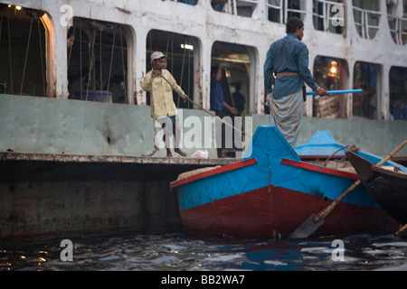 Alltag in Bangladesch; Ein kleines Boot bindet an eine Personenfähre in Dhaka. Stockfoto