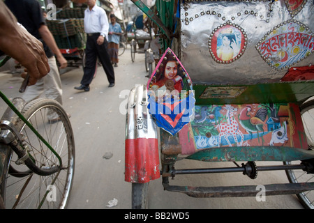 Alltag in Bangladesch; Fahrradrikschas übergeben einander mit ihren bunten Taxis auf einer Straße in Dhaka. Stockfoto