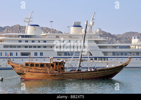 Dhow & die Principal Royal Yacht Al Said betrieben von Oman Royal Yacht Squadron als Luxus Seefahrt VIP Transport AT Muttrah Hafen Port Muscat Oman Stockfoto