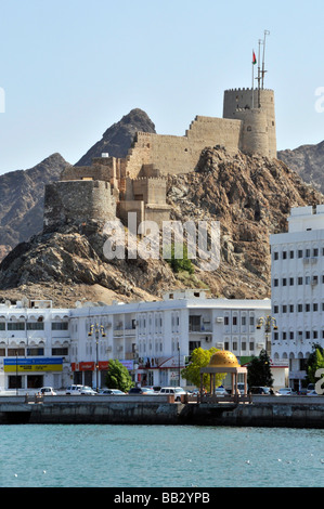 Historisches Muttrah Muscat Fort auf einem Hügel über der Hafenpromenade & Moderne Gebäude entlang der Coniche Promenade Straße Oman Golf von Oman, Naher Osten Stockfoto