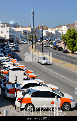 Muttrah Muscat langen Reihe von geparkten Taxi Taxis neben Wasser Schnellstraße mit Moschee jenseits Stockfoto