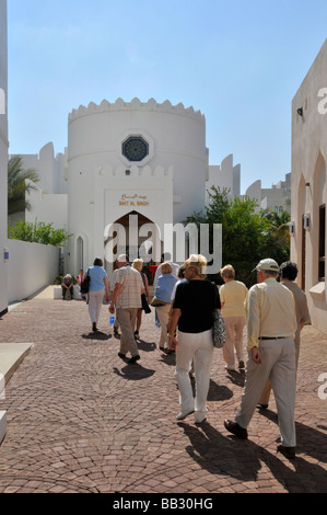 Muscat-Oman-Reiseleiter & Erwachsene aus Kreuzfahrt Schiff Trainer Ausflug nähert sich der Haupteingang des Bait Al Zubair Museum Stockfoto