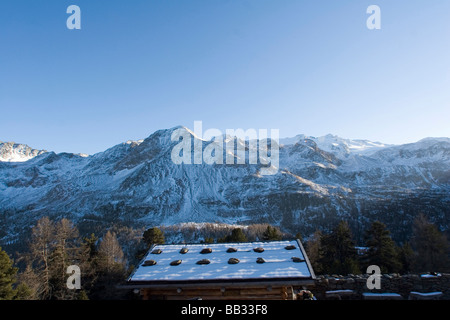 Traditionelle Berghütte mit Dachsteinen, halten Sie die hölzernen Fliese oder Schindeldach und als Schnee Pause zu handeln. Italienische Alpen Stockfoto