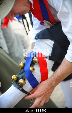 Ein Morris Mann legt seine Glocken auf seine Beine vor dem Tanzen in der englischen Folk Morris tanzen. Bild von Jim Holden. Stockfoto