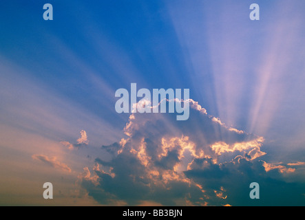 Sonnenstrahlen, die durch Wolken strömen. Stockfoto