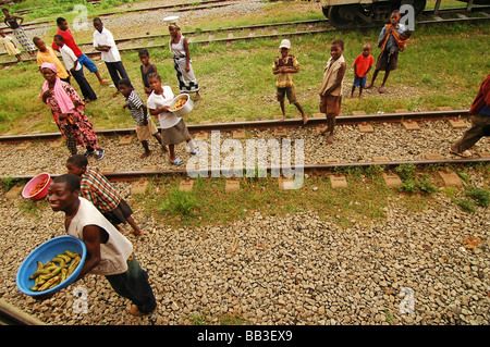 MOSAMBIK. Gruppe der afrikanischen Männer, Frauen & Kinder stehen auf einem Bahngleis Stockfoto