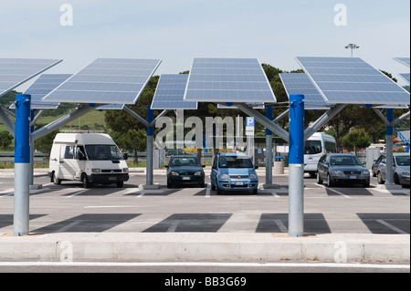 Solarzellen, die zur gleichzeitigen Abschattung geparkter Autos und zur Stromerzeugung auf einer italienischen Autobahn in der Toskana, Italien, verwendet wurden Stockfoto