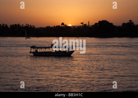 Kleiner touristischer Boot auf dem Nil bei Luxor bei Sonnenuntergang Stockfoto