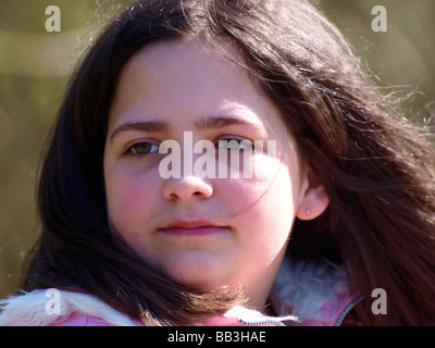 Junge Brünette Mädchen eine Ohrringe tragen wir auf der linken Seite der Kamera. Stockfoto