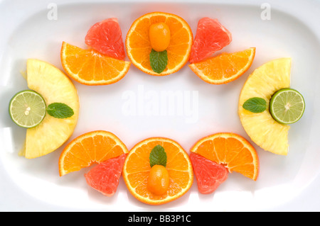 Künstlerische, kulinarische Anordnung der Früchte Gewürze Kräuter Cookies und Paprika machen eine schöne Grafik von gesunden Snacks auf dem Teller Stockfoto