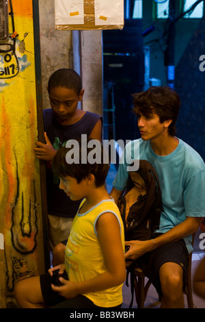 Favela-Kinder spielen von Videospielen in einem kleinen Laden in Santa Marta Vorstadt, Rio De Janeiro, Brasilien. Stockfoto