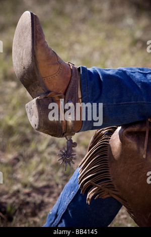 USA, Oregon, Seneca, Ponderosa Ranch. Nahaufnahme der gekreuzten Beinen ein Cowboy Stiefel, Chaps und Sporen zeigen. Stockfoto