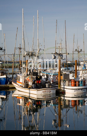 OR, Küste von Oregon, Newport, kommerzielle Fischereiflotte im Hafen von Newport, Yaquina Bay Bridge im Hintergrund Stockfoto