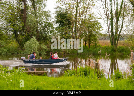 Eine Familie, genießen eine Bootsfahrt auf dem Fluss Waveney auf ein kleines Motorboot auf den Norfolk Broads im Frühjahr Stockfoto