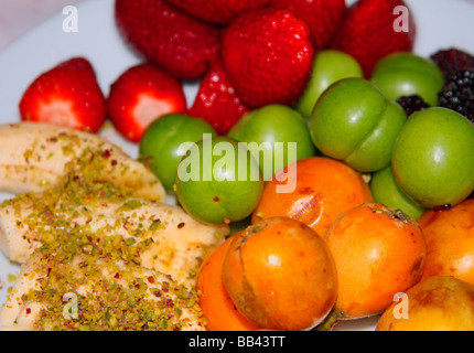 Obst, wie Erdbeeren, Bananen und grüne Pflaumen Stockfoto